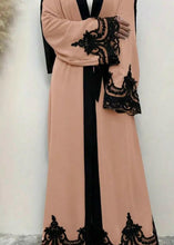 WOMAN WEARING PINK AND BLACK ABAYA 2025